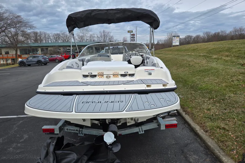 Slide: The Image of 2010 Bayliner 185 boat on trailer, parked outdoors with overcast sky. - 2