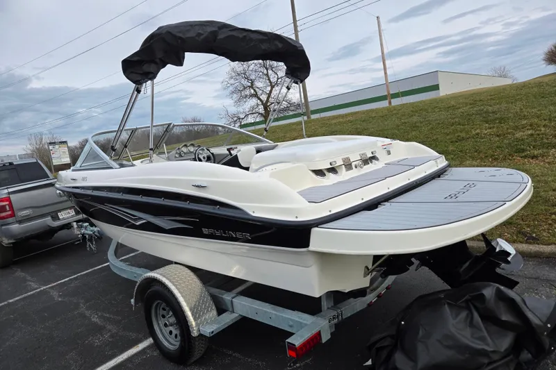 Slide: The Image of 2010 Bayliner 185 boat on trailer, parked outdoors, with cover partially on. - 3