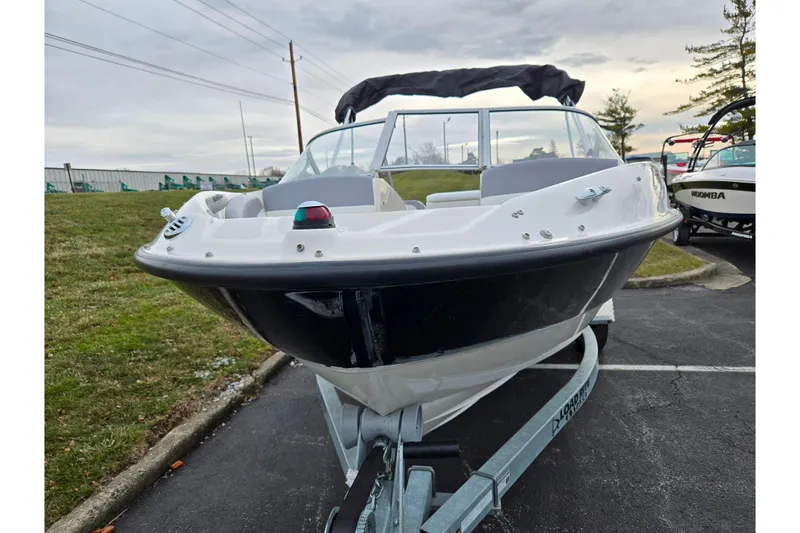 Slide: The Image of 2010 Bayliner 185 boat on trailer, parked outdoors, overcast sky. - 6