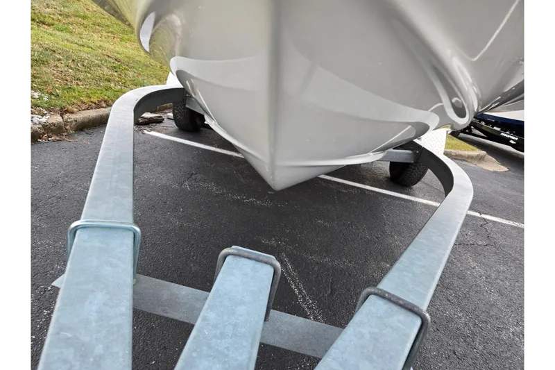 Slide: The Image of 2010 Bayliner 185 boat on trailer, parked on asphalt near grassy area. - 7