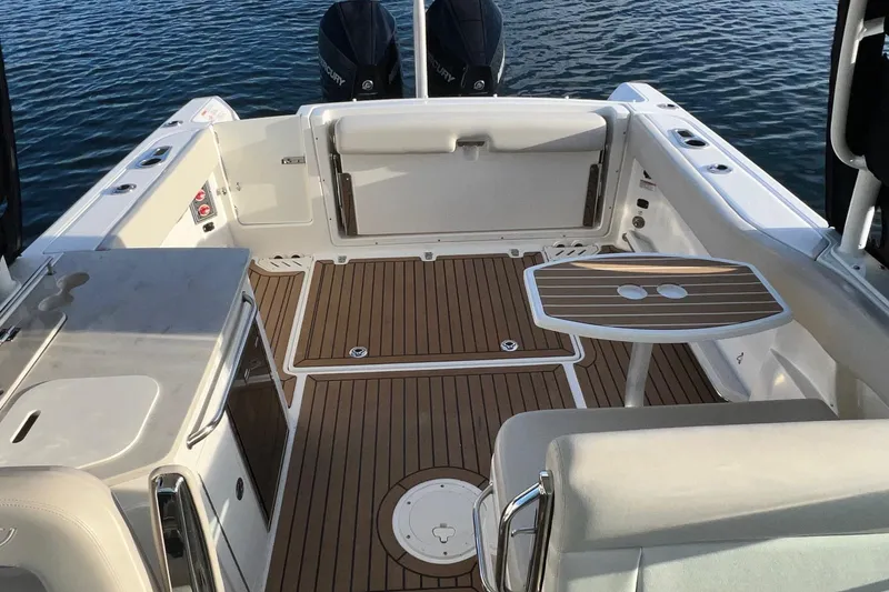 Slide: The Image of 2019 Boston Whaler 270 Vantage boat interior with wooden deck and seating area. - 10