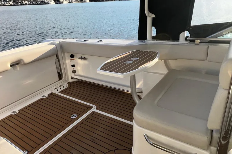 Slide: The Image of 2019 Boston Whaler 270 Vantage interior with teak flooring and seating by the water. - 12