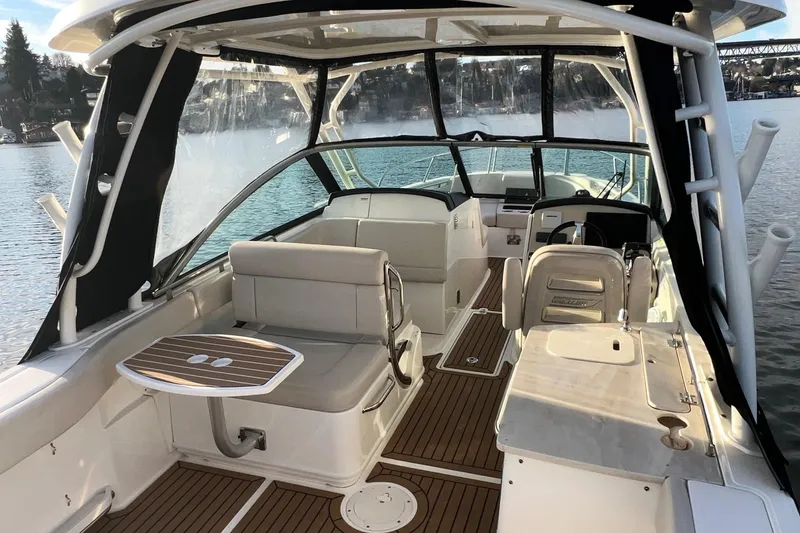 Slide: The Image of 2019 Boston Whaler 270 Vantage boat interior with seating and helm, on calm water. - 14
