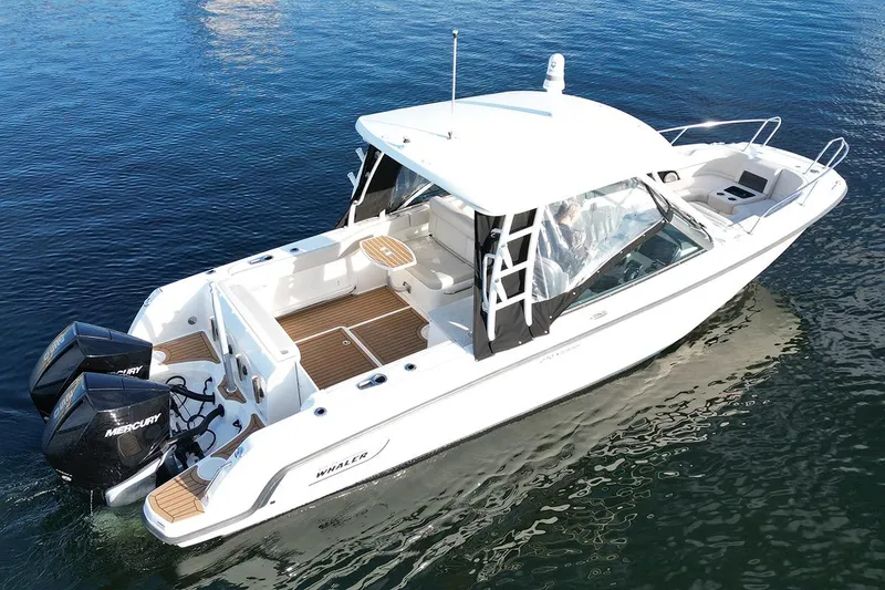 Slide: The Image of 2019 Boston Whaler 270 Vantage boat on calm water, featuring dual Mercury engines. - 2