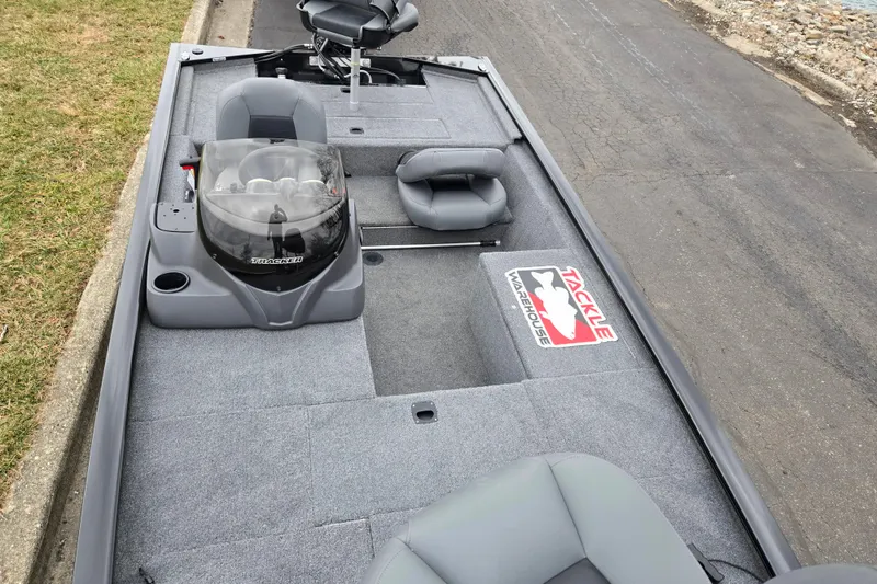 Slide: The Image of 2025 Tracker Pro 170 boat interior with gray seating and Tackle Warehouse logo. - 18