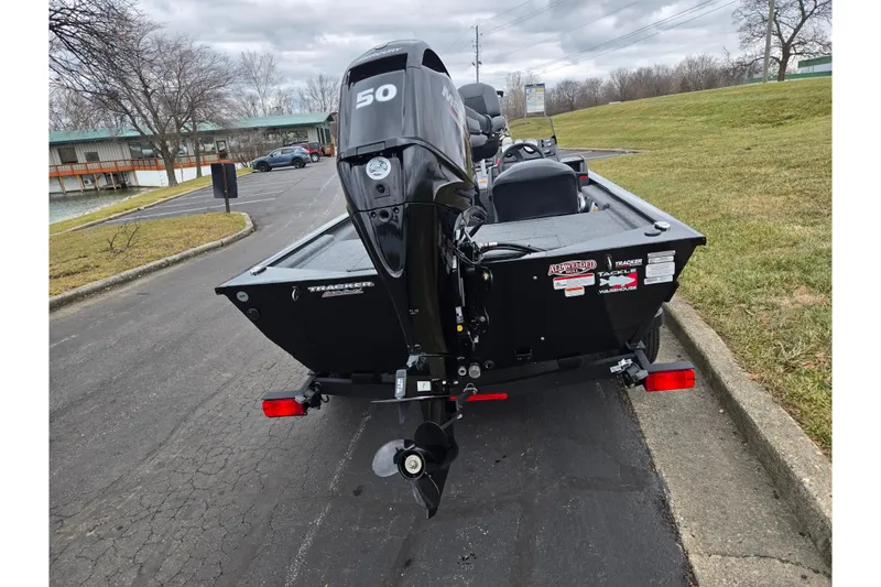 Slide: The Image of 2025 Tracker Pro 170 boat with a 50 HP motor, parked on a paved road. - 2