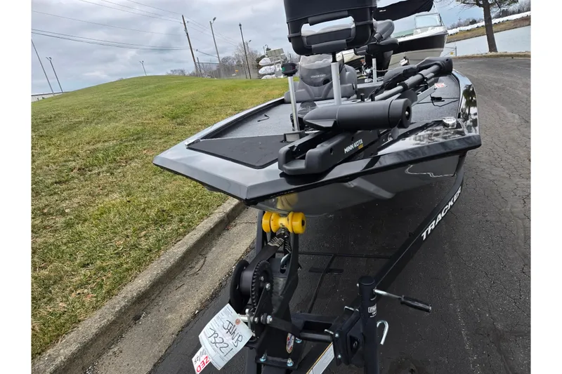 Slide: The Image of 2025 Tracker Pro 170 boat on trailer, parked near grassy area and road. - 7