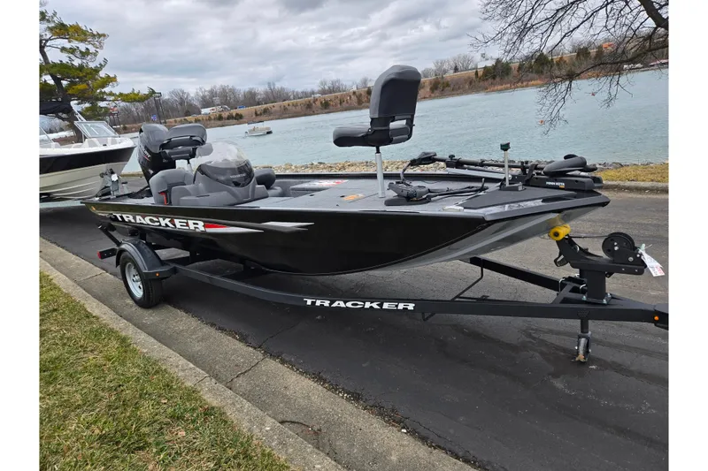 Slide: The Image of 2025 Tracker Pro 170 boat on trailer by a riverbank, overcast sky. - 9