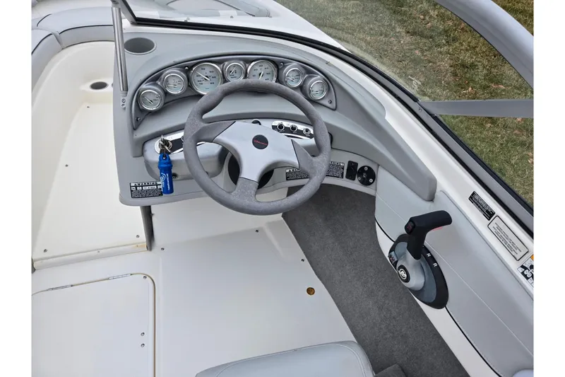 Slide: The Image of 2011 Bayliner 195 boat dashboard with steering wheel and control panel. - 12