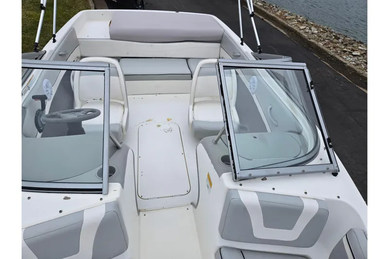 Slide: The Image of 2011 Bayliner 195 boat interior with seating and steering wheel near water. - 18