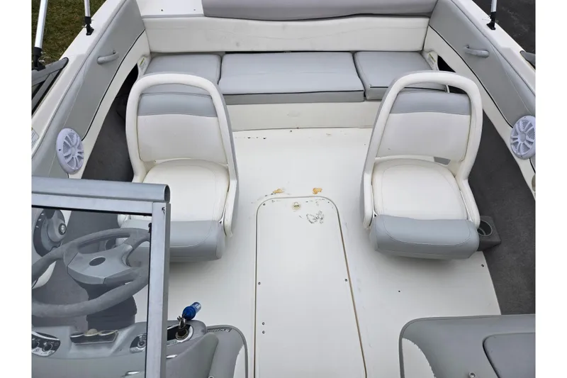 Slide: The Image of 2011 Bayliner 195 boat interior with white and gray seating and steering wheel. - 19