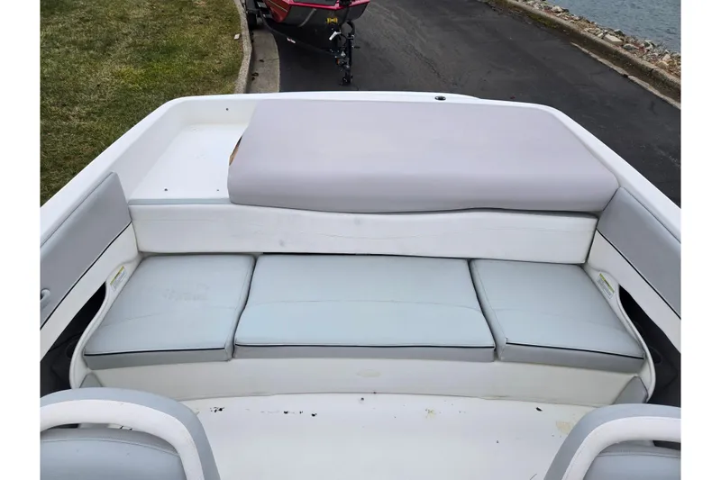 Slide: The Image of 2011 Bayliner 195 boat interior with cushioned seating and storage area. - 20