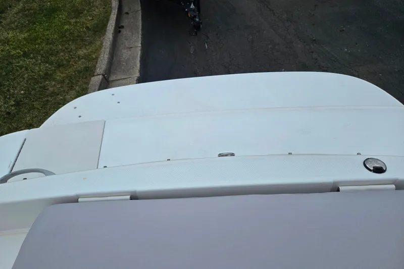 Slide: The Image of 2011 Bayliner 195 boat stern view with white deck and pavement background. - 22