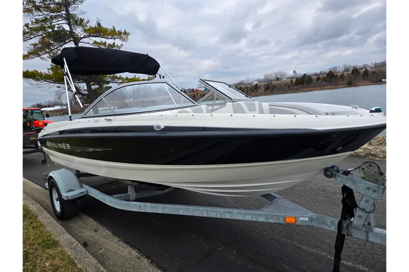 Slide: The Image of 2011 Bayliner 195 boat on trailer by lakeside, under cloudy sky. - 8