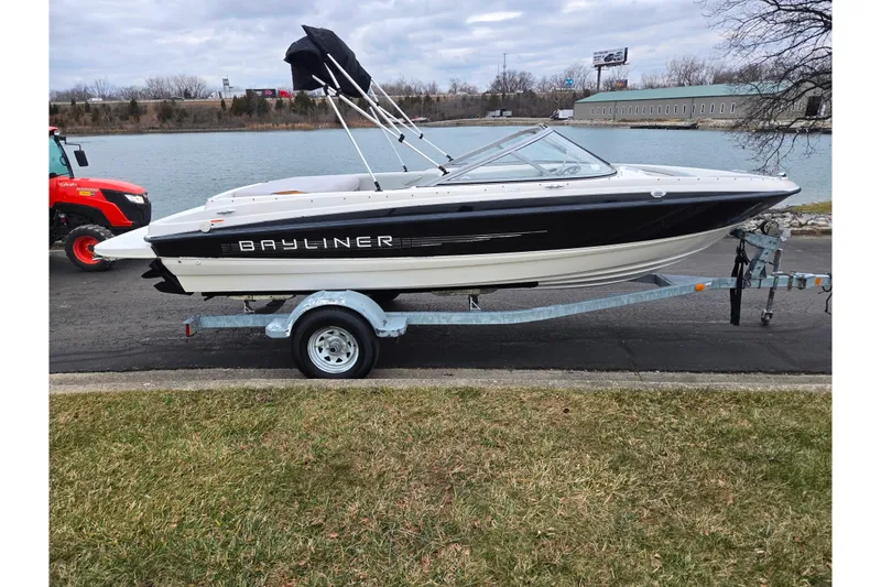 Slide: The Image of 2011 Bayliner 195 boat on trailer by a lake, overcast sky. - 9