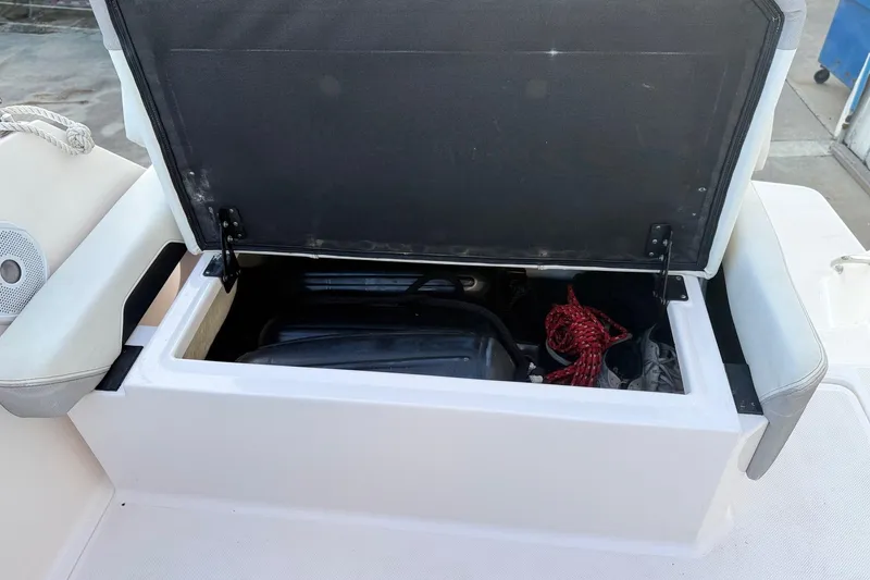 Slide: The Image of Open storage compartment on 2020 Regal 26 XO boat with ropes and equipment inside. - 19