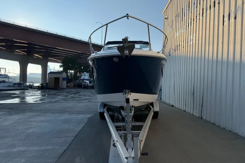 Slide: The Image of 2020 Regal 26 XO boat on trailer near waterfront and bridge. - 3
