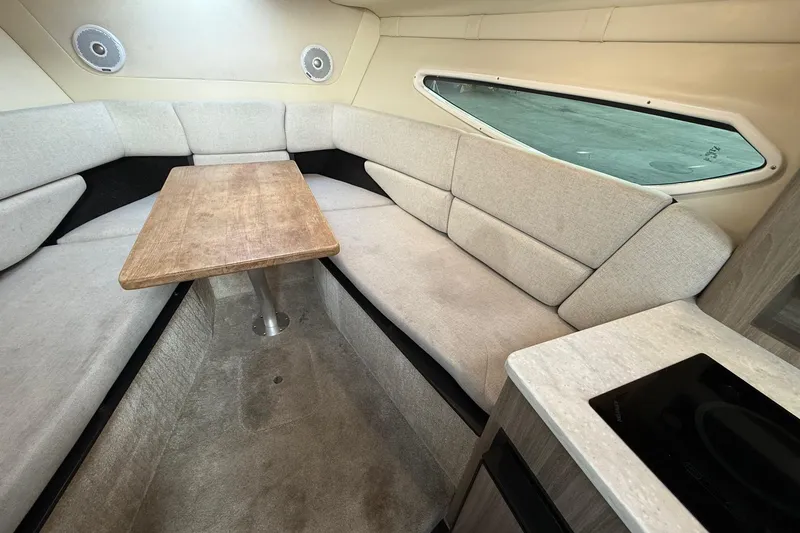 Slide: The Image of 2020 Regal 26 XO boat interior with cozy seating and wooden table. - 30