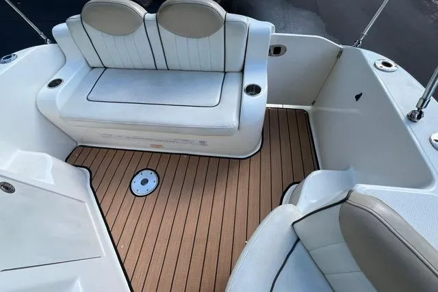 Slide: The Image of 2008 Sea Ray 240 Sundancer boat interior with cushioned seating and wood-style flooring. - 11