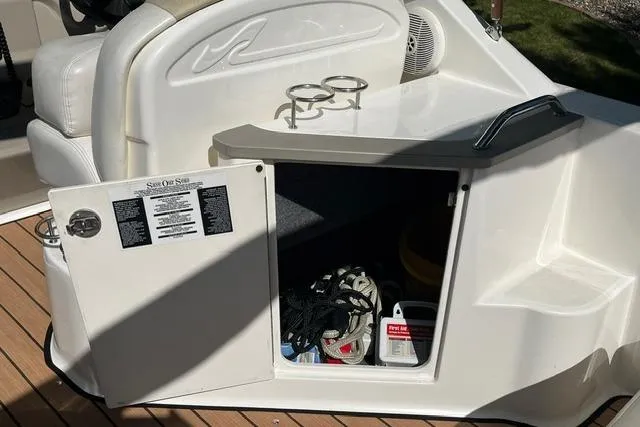 Slide: The Image of 2008 Sea Ray 240 Sundancer boat storage compartment with open door, revealing ropes and supplies. - 12