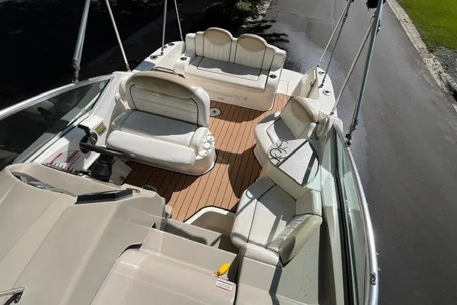 Slide: The Image of 2008 Sea Ray 240 Sundancer boat interior with white seating and wood flooring. - 13