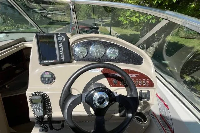 Slide: The Image of 2008 Sea Ray 240 Sundancer boat dashboard with steering wheel and navigation instruments. - 15
