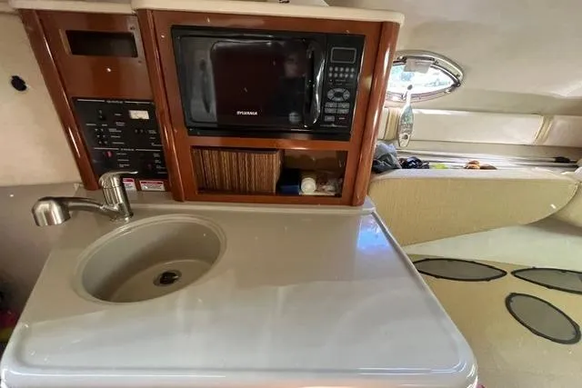 Slide: The Image of 2008 Sea Ray 240 Sundancer cabin with sink, microwave, and storage. - 21