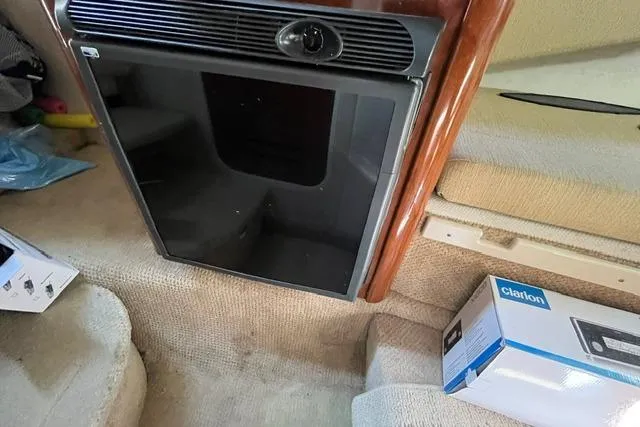 Slide: The Image of 2008 Sea Ray 240 Sundancer cabin interior with compact refrigerator and Clarion audio box. - 22