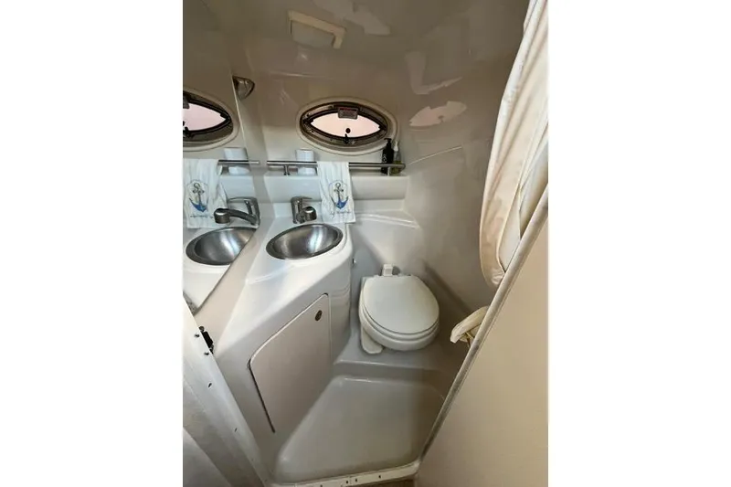 Slide: The Image of 2008 Sea Ray 240 Sundancer bathroom with sink, toilet, and porthole window. - 23