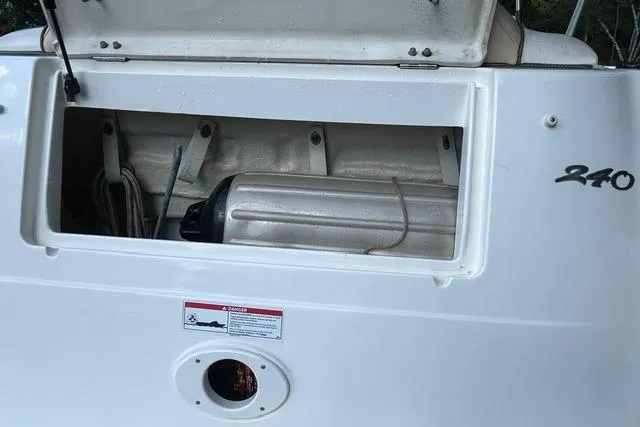 Slide: The Image of 2008 Sea Ray 240 Sundancer storage compartment with equipment inside. - 7