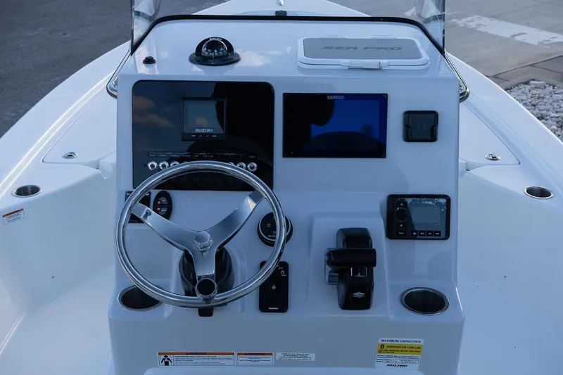 Slide: The Image of 2026 Sea Pro 230 Bay boat dashboard with steering wheel and electronic controls. - 11