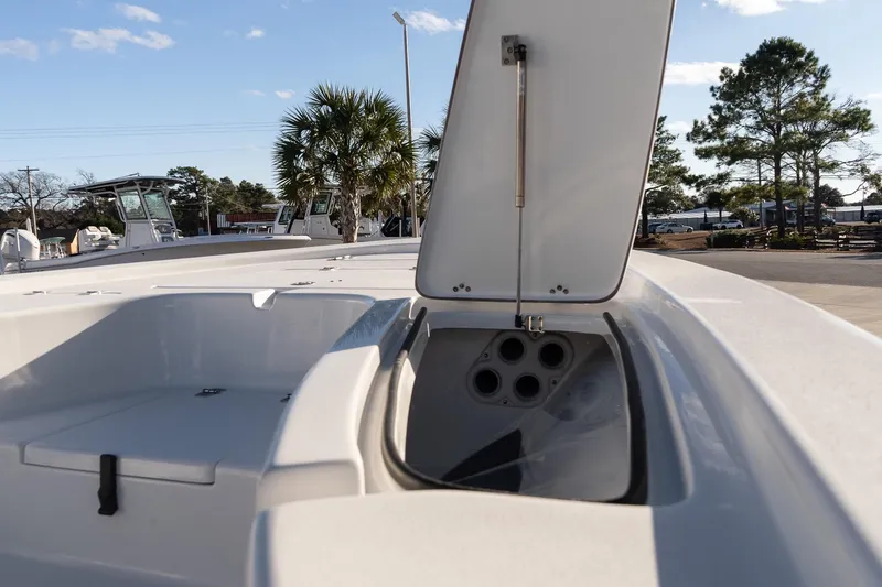 Slide: The Image of 2026 Sea Pro 230 Bay boat with open storage compartment, palm trees in background. - 15