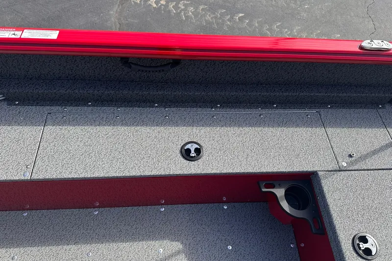 Slide: The Image of 2026 Lund 1800 Explorer Sport boat interior with gray textured flooring and red trim. - 18