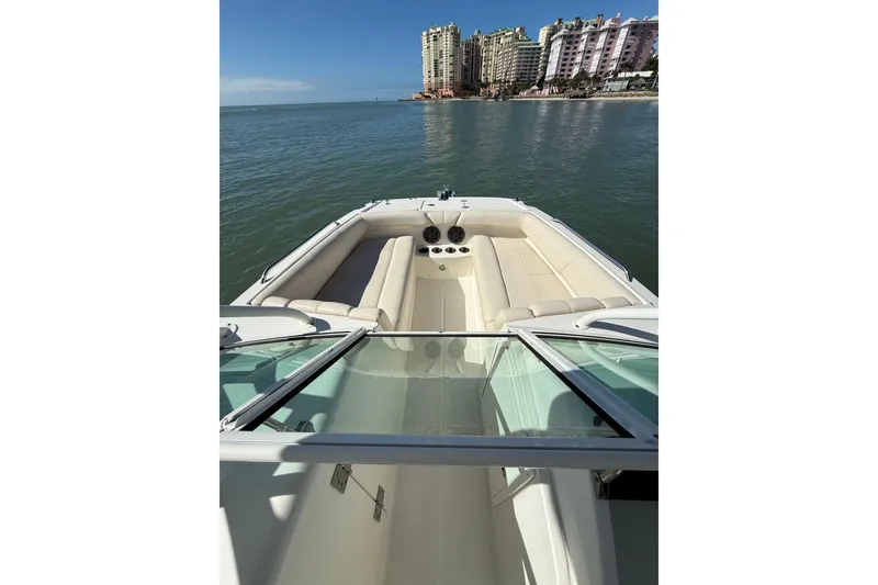 Slide: The Image of 2017 World Cat 230 SD boat with spacious seating, cruising near waterfront buildings. - 12