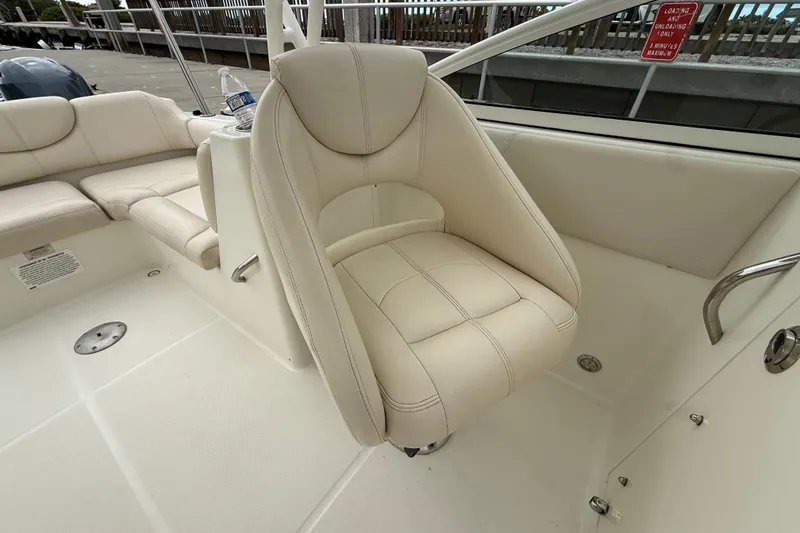 Slide: The Image of 2017 World Cat 230 SD boat interior with beige seating and cup holder. - 19