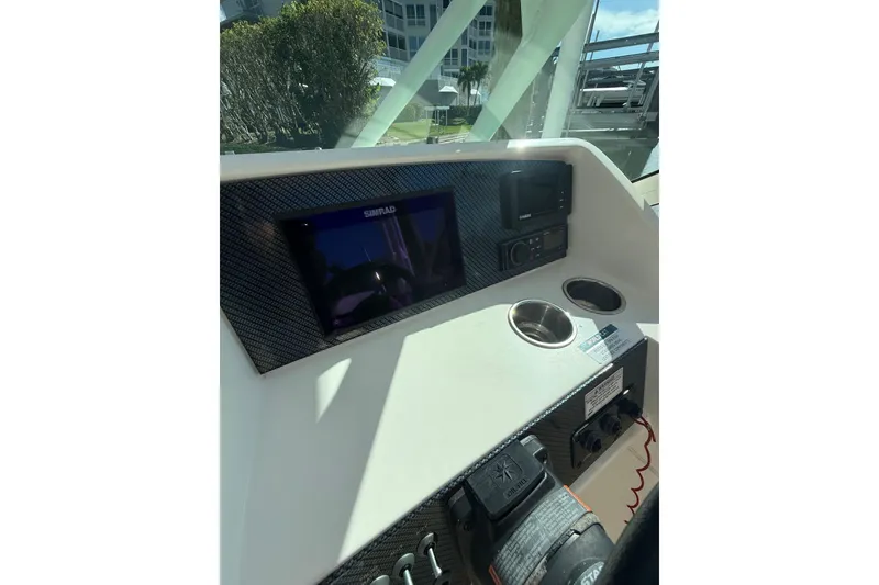 Slide: The Image of 2017 World Cat 230 SD boat dashboard with Simrad display and cup holders. - 24