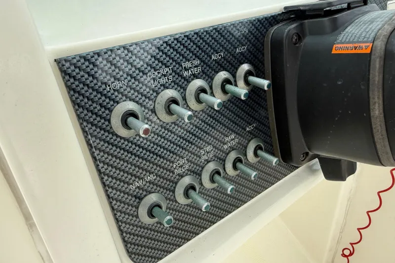 Slide: The Image of Control panel of 2017 World Cat 230 SD boat with labeled switches. - 26