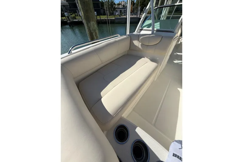 Slide: The Image of 2017 World Cat 230 SD boat interior with beige seating and cup holders. - 6