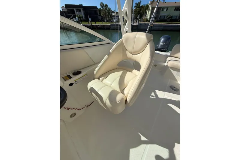Slide: The Image of 2017 World Cat 230 SD boat interior with beige captain's chair and waterfront view. - 9