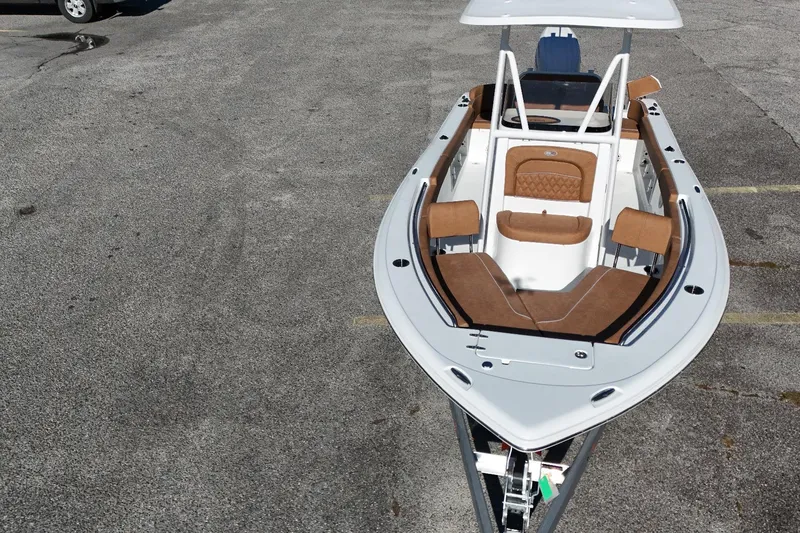 Slide: The Image of 2026 Sea Hunt Ultra 219 boat with brown seating, parked on asphalt. - 3