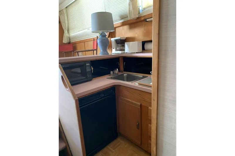 Slide: The Image of 1988 Silverton 34 Convertible boat kitchen with sink, microwave, and lamp. - 6