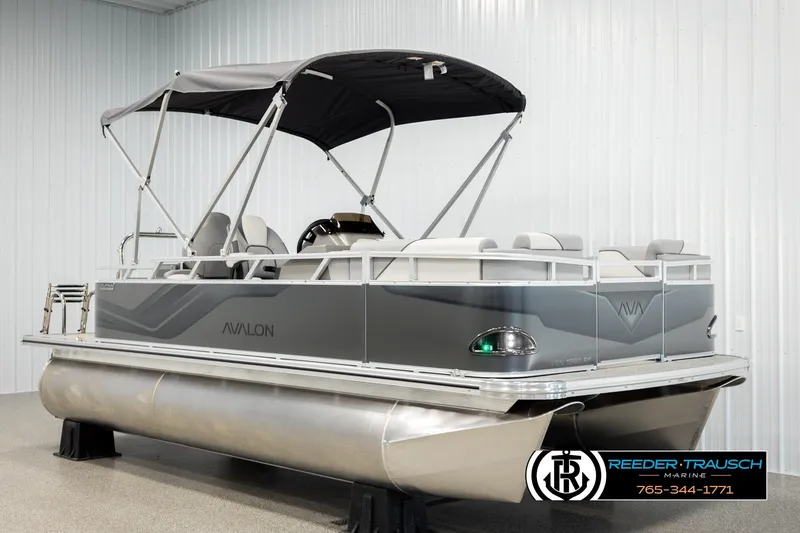 Slide: The Image of 2026 Avalon VEN RF pontoon boat with canopy in showroom, Reeder-Trausch Marine logo visible. - 3