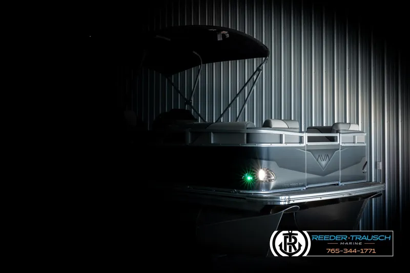 Slide: The Image of 2026 Avalon VEN RF pontoon boat in dimly lit showroom, highlighting sleek design. - 4