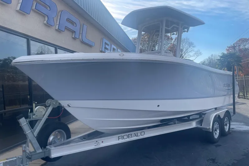 The Image of 2024 Robalo R230 Center Console boat on trailer outside dealership. - 0