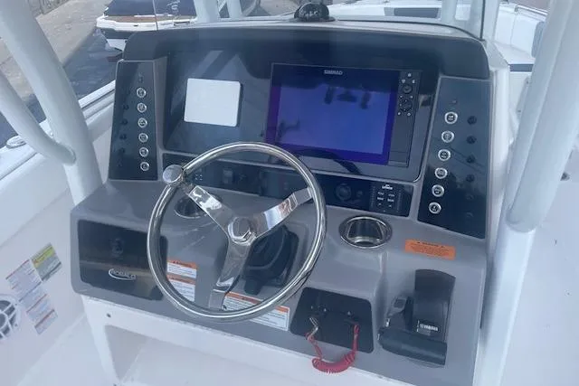 Slide: The Image of 2024 Robalo R230 Center Console boat dashboard with steering wheel and navigation system. - 5