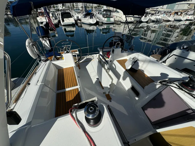 Slide: The Image of 2021 Beneteau Oceanis 35.1 sailboat cockpit with dual steering wheels, docked in marina. - 18
