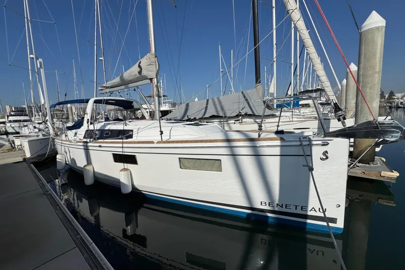 Slide: The Image of 2021 Beneteau Oceanis 35.1 sailboat docked at marina under clear blue sky. - 2