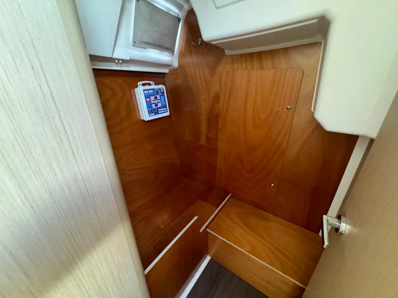 Slide: The Image of 2021 Beneteau Oceanis 35.1 interior with wooden finish and compact storage space. - 34