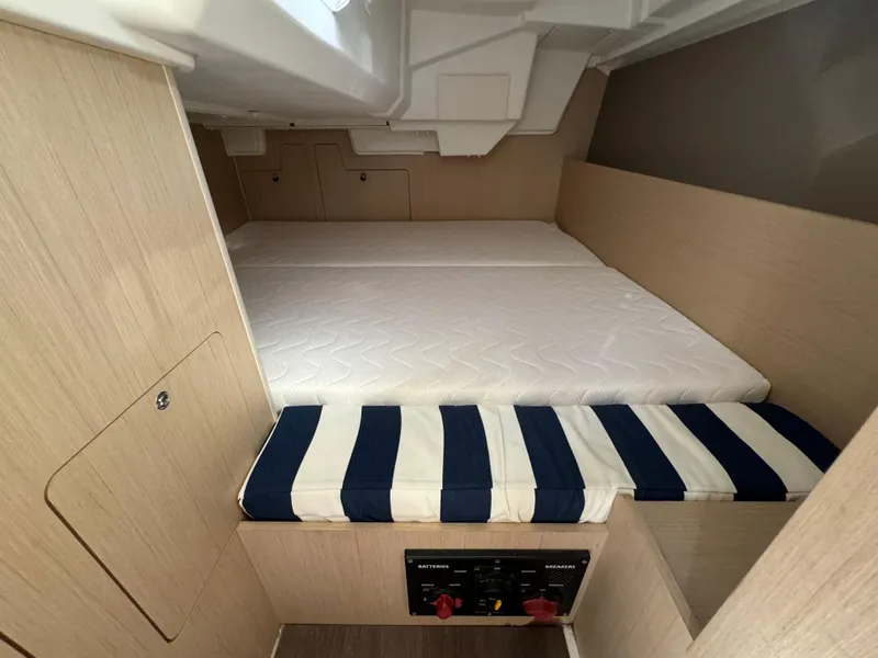 Slide: The Image of Interior cabin of 2021 Beneteau Oceanis 35.1 with striped cushions and wooden finish. - 35