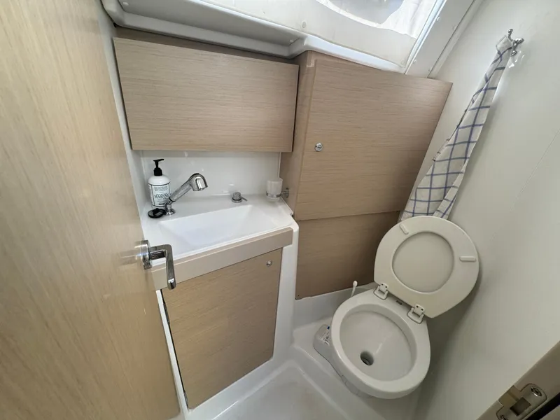 Slide: The Image of Beneteau Oceanis 35.1 2021 yacht bathroom with sink, toilet, and storage cabinets. - 39
